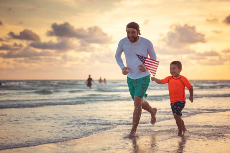 Father and son run on a beach